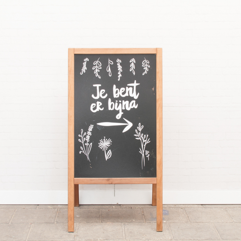 Stoepbord: Je bent er bijna ->